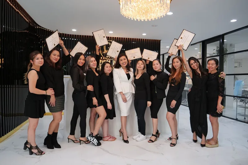 A graduating class holding their certificates