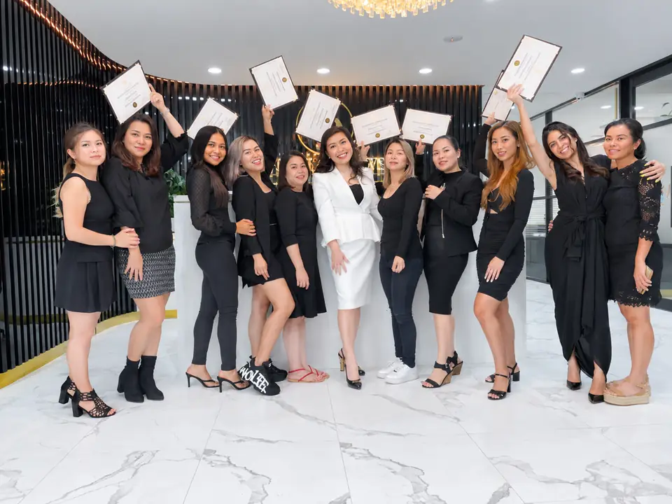 A graduating class at Golden Brows Academy, holding their certificates